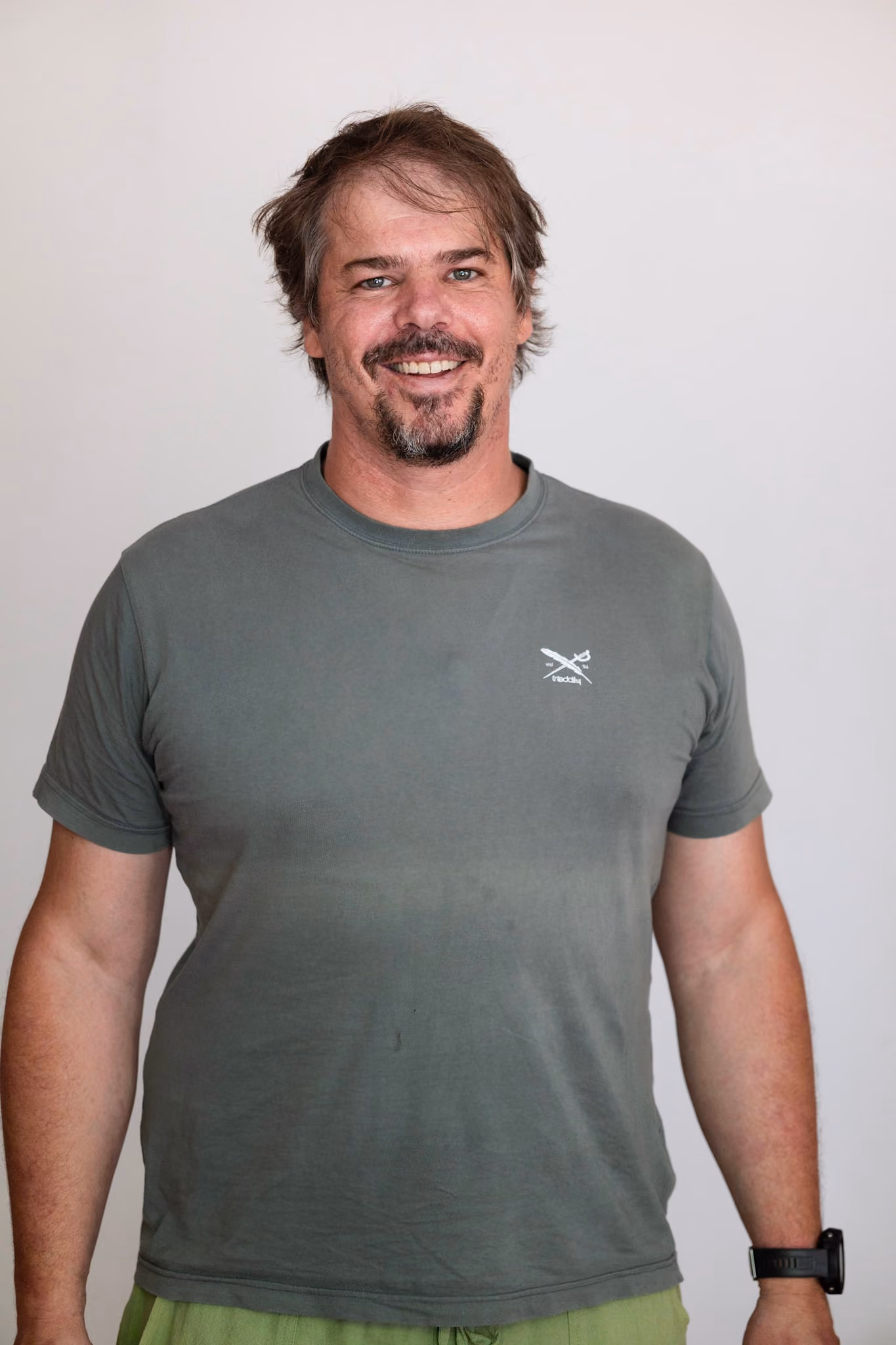 Portrait aus dem Kollektiv, olivgrünes T-Shirt vor heller Wand